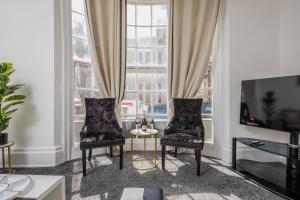 a living room with two chairs and a table at Luxury, very central and spacious house in Brighton & Hove