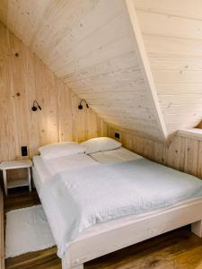 a bed in a room with a wooden ceiling at Bieszczadzkie Chatki - Willa Stasia in Ustrzyki Dolne