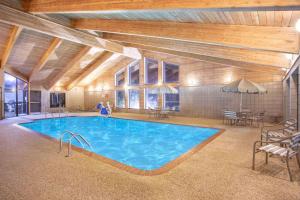 una gran piscina en una habitación con mesa y sillas en AmericInn by Wyndham Ankeny/Des Moines, en Ankeny