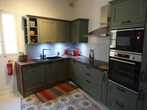 uma cozinha com armários verdes e um lavatório em 60 Indri Borg Townhouse em Rabat