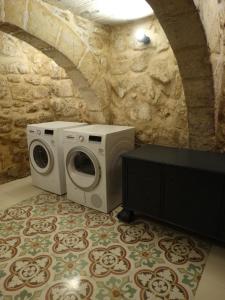 pralka i suszarka w pokoju z kamienną ścianą w obiekcie 60 Indri Borg Townhouse w mieście Rabat