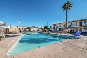 a swimming pool in a parking lot with a palm tree at Rodeway Inn Phoenix North I-17 in Phoenix