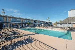 a large swimming pool with chairs and a building at Rodeway Inn Phoenix North I-17 in Phoenix