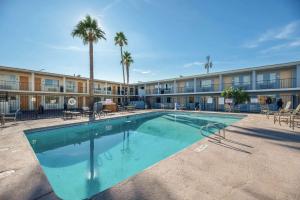 uma piscina em frente a um edifício com palmeiras em Rodeway Inn Phoenix North I-17 em Phoenix