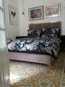 een slaapkamer met een bed met bloemen erop bij 60 Indri Borg Townhouse in Rabat