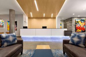 a lobby with two couches and a reception desk at Wingate by Wyndham Bronx Haven Park in Bronx