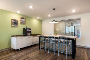 a kitchen with a table and chairs in a room at WoodSpring Suites Greensboro - High Point North in Greensboro