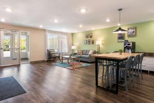 WoodSpring Suites Greensboro - High Point North في جرينسبورو: غرفة معيشة مع طاولة وأريكة