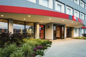 an office building with a courtyard with plants and flowers at Ibis Milano Fiera in Lainate