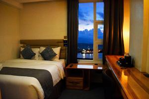 una camera d'albergo con un letto e una finestra di Sempre Premier Inn - MACTAN AIRPORT HOTEL a Mactan