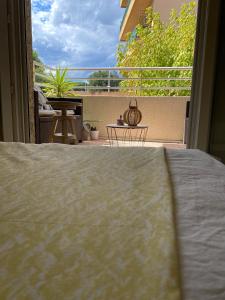 a bed in a room with a view of a balcony at Centre ville, parking privé in Perpignan