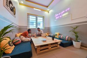 dos personas sentadas en una mesa en una habitación en The Hosteller Fort Kochi, en Kochi