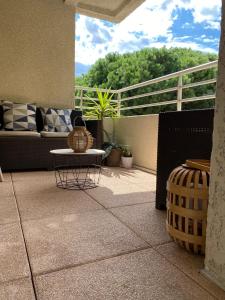 a patio with a couch and a table on a balcony at Centre ville, parking privé in Perpignan