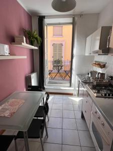 a kitchen with a table and a view of a balcony at Arco Antico in Alba