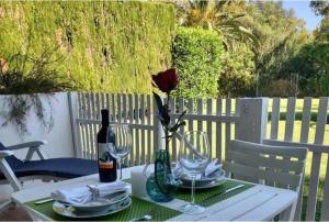 Biały stół z kwiatem w wazie w obiekcie Puerto Banus Apartment near beachfront, big sunny terrace, pool, tennis court, parking & movies projector w Marbelli