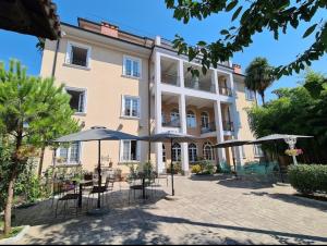 un edificio con tavoli e ombrelloni di fronte di Hotel TREVA a Shkodër