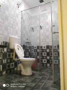 a bathroom with a toilet and a glass shower at Casa de joana deluxe in Calangute