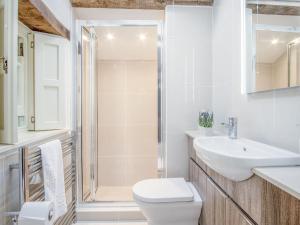 a bathroom with a toilet and a sink and a shower at Primrose Cottage - HW7100 in Amroth