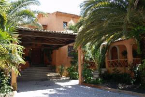 uma casa com palmeiras em frente em Hotel Quinta Da Lagoa na Praia de Mira