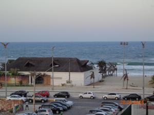 un estacionamiento con autos estacionados al lado del océano en VG Fun Residence - Fortaleza Flats, en Fortaleza