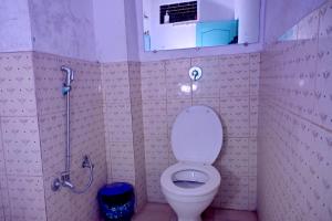 a small bathroom with a toilet and a shower at BANARAS REST HOUSE in Varanasi