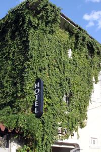 a ivy covered building with a sign on it at Hotel TREVA in Shkodër