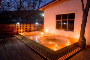 a jacuzzi tub in the backyard of a house at night at Casa Pedro in Blăjani