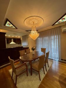 a dining room with a table and chairs and a chandelier at Jackman apartments in Bitola