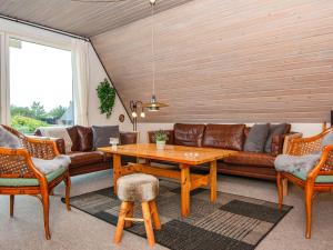 a living room with a couch and a table and chairs at 6 person holiday home in Hvide Sande in Hvide Sande