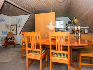 a kitchen and dining room with a wooden table and chairs at 6 person holiday home in Hvide Sande in Hvide Sande