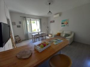 uma sala de estar com um sofá e uma mesa em Mas provençal au cœur des vergers em Vallabrègues