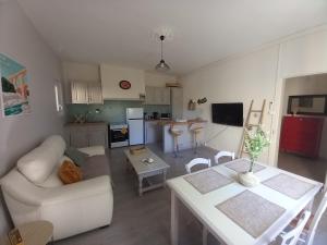 uma sala de estar com um sofá, uma mesa e uma cozinha em Mas provençal au cœur des vergers em Vallabrègues