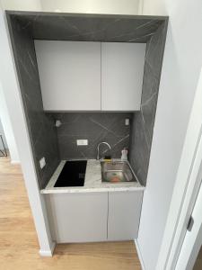 a kitchen with white cabinets and a sink at Lungomare Apartments in Petrovac na Moru