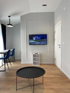 a living room with a table and a tv on the wall at Lungomare Apartments in Petrovac na Moru