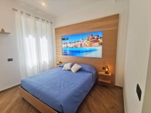 a bedroom with a blue bed and a painting on the wall at Maqueda Mood in Palermo