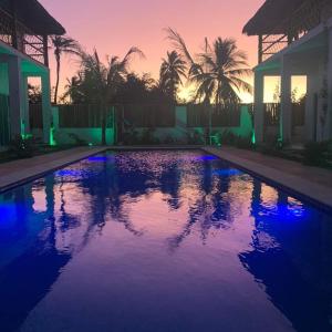 una piscina con tramonto sullo sfondo di Sirena Village a São Miguel do Gostoso