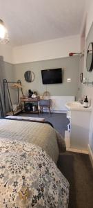 pokój hotelowy z łóżkiem i telewizorem w obiekcie Rigsbys Guesthouse Doncaster w mieście Doncaster