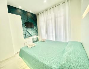 a bedroom with a blue bed and a window at IL VIAGGIATORE RELAIS SUL MARE in Gaeta