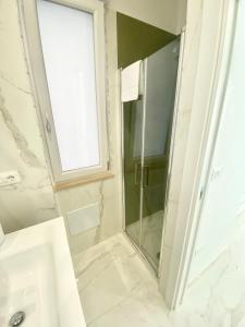 a bathroom with a shower and a sink and a window at IL VIAGGIATORE RELAIS SUL MARE in Gaeta