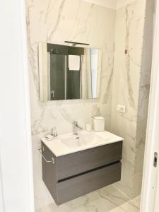 a white bathroom with a sink and a mirror at IL VIAGGIATORE RELAIS SUL MARE in Gaeta