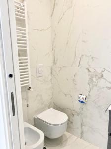 a white bathroom with a toilet and a sink at IL VIAGGIATORE RELAIS SUL MARE in Gaeta