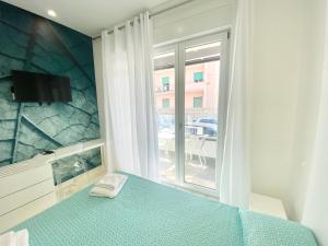 a bedroom with a blue bed and a window at IL VIAGGIATORE RELAIS SUL MARE in Gaeta