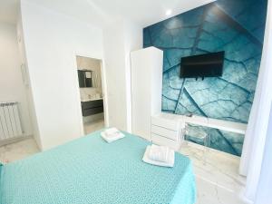 a room with a bed and a tv on a wall at IL VIAGGIATORE RELAIS SUL MARE in Gaeta