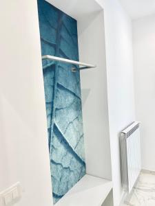 a shower in a white bathroom with blue wallpaper at IL VIAGGIATORE RELAIS SUL MARE in Gaeta
