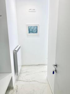 a white bathroom with a shower and a glass door at IL VIAGGIATORE RELAIS SUL MARE in Gaeta
