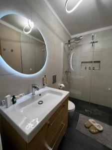 a bathroom with a sink and a shower with a mirror at La Baita Limone Riserva Bianca Ski-in Ski-out Seggiovia Morel 1 in Limone Piemonte