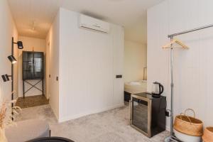 Zimmer mit einer weißen Wand und einem Zimmer mit einem Bett in der Unterkunft Apartamentai Ešerinėje in Neringa