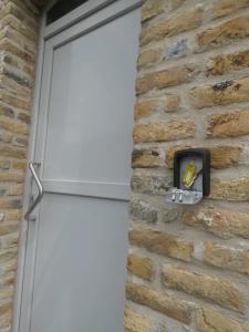 uma porta branca numa parede de tijolos com aabinet em L'eau de vie em Alveringem