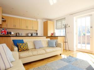 a living room with a couch and a kitchen at Half Turn Cottage in Whitstable