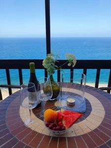 un tavolo con bicchieri da vino e un cesto di frutta di Very romantic seaview appartment with warm pool a Patalavaca